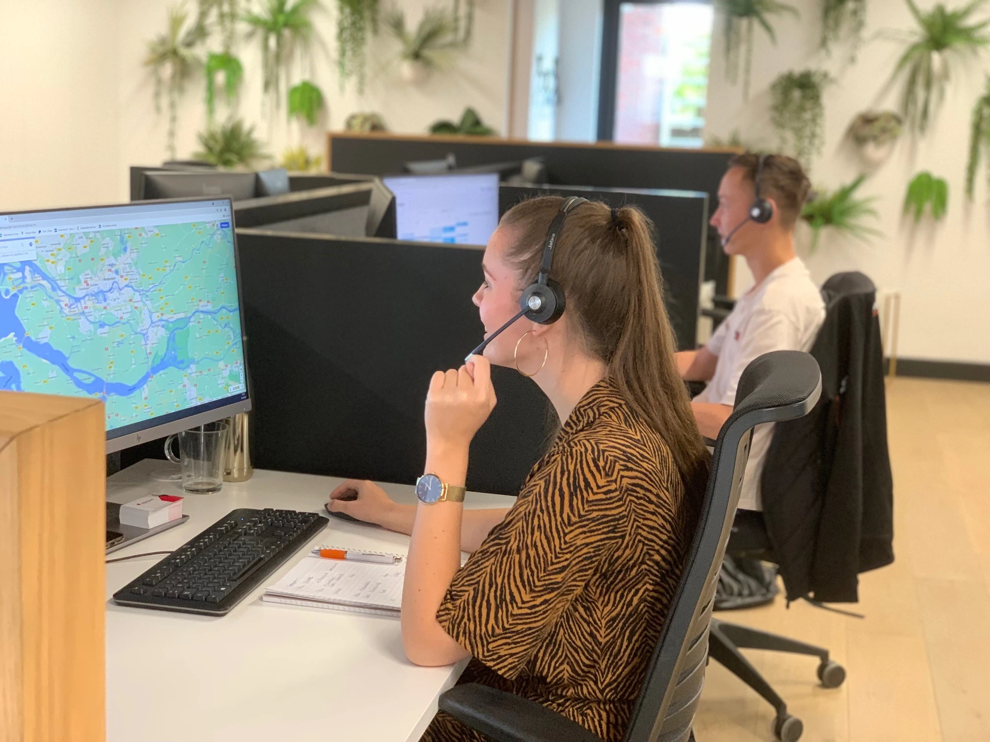 Collega’s van Service & Office Support met headset achter hun bureau