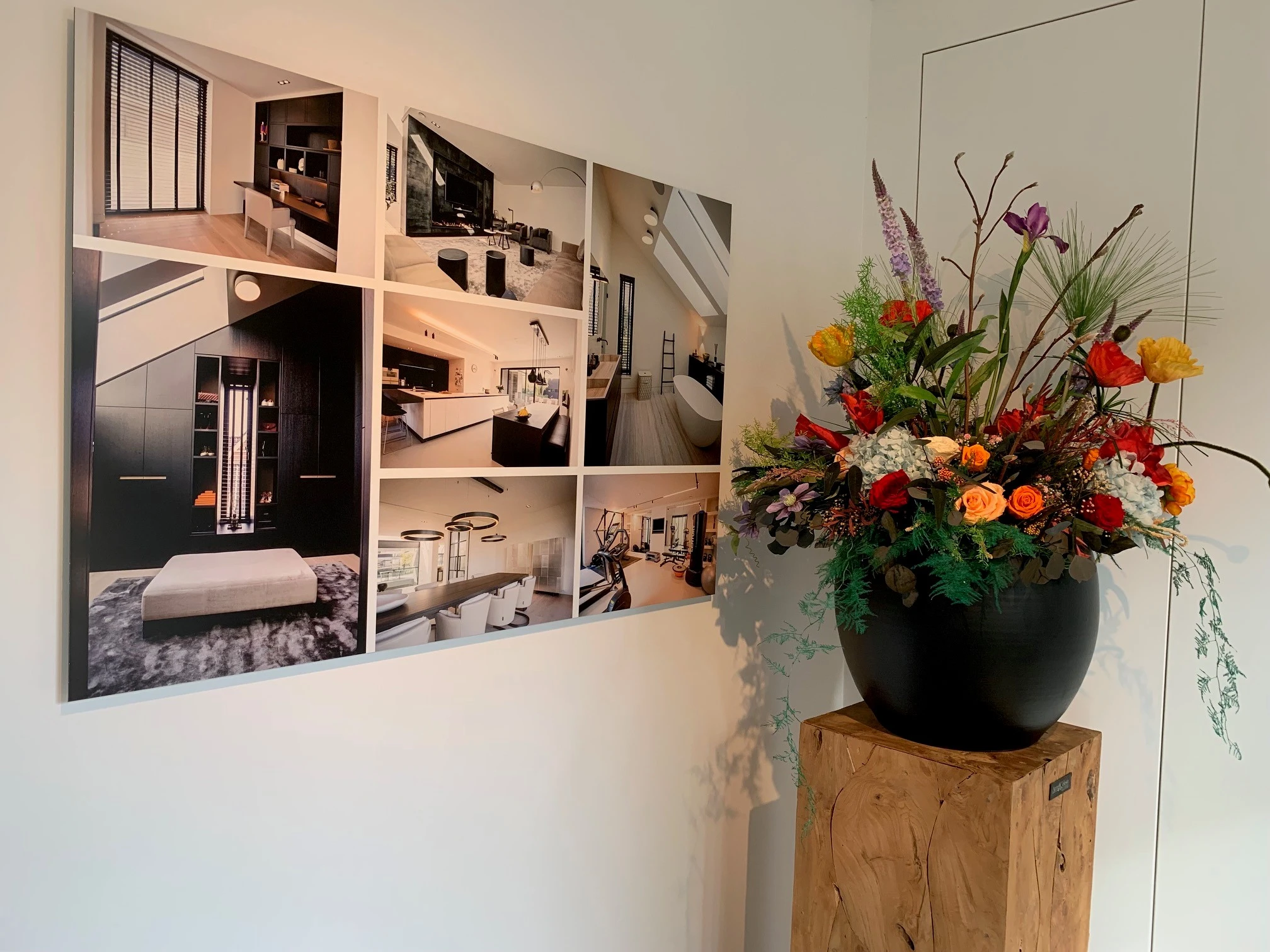 Fotowand met projectfoto’s en een bloemstuk in de ontvangstruimte