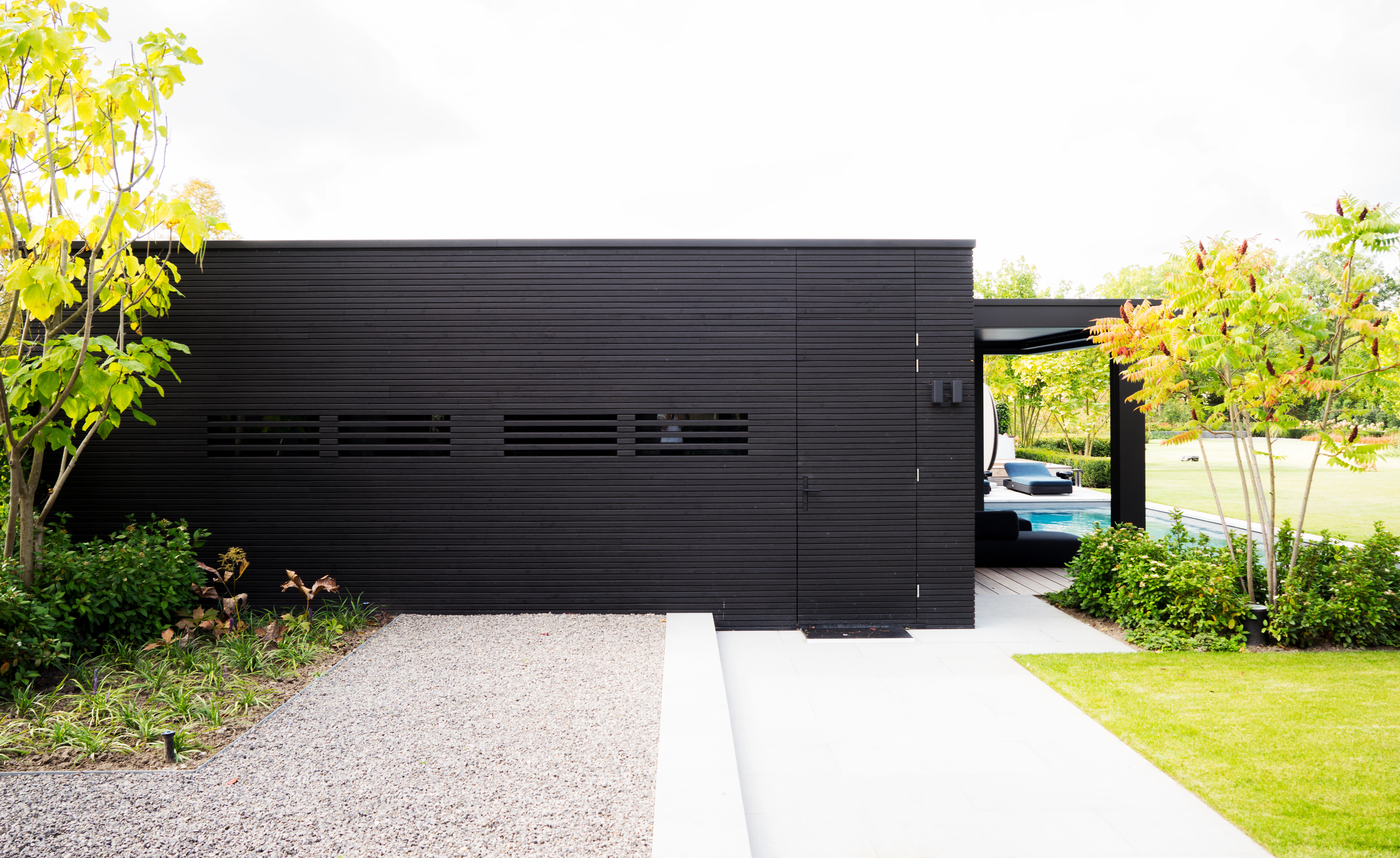 Zwart gevelhout van het poolhouse met overkapt terras en zwembad